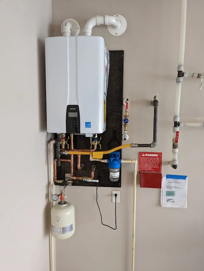 Professional plumber installing copper piping in a Kenmore home